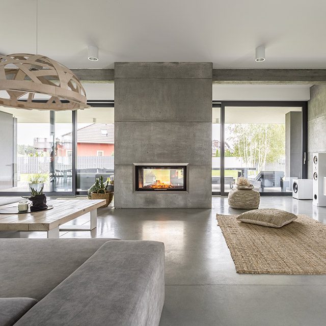 Spacious villa interior with cement wall effect and fireplace